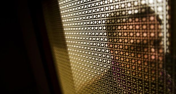 Photo of man in church confessional.