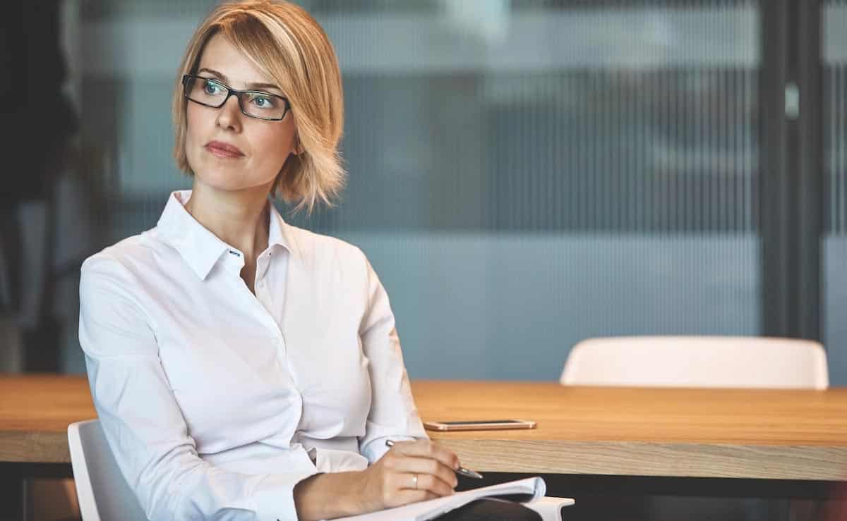 Photo of young lady in a chair making notes on paper.