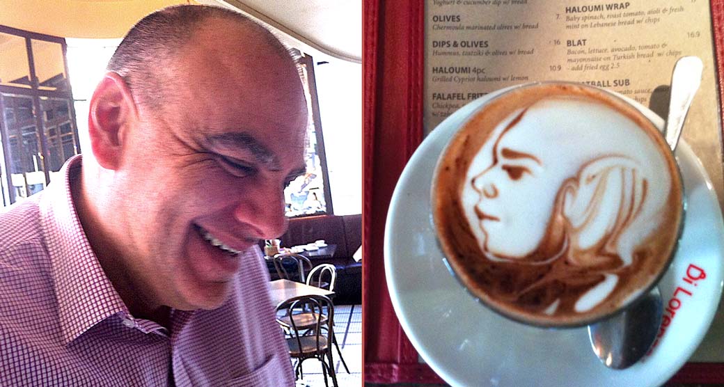 Photo of coffee cup with artwork of man on top.